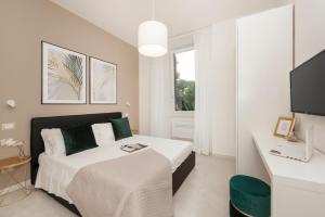 a white bedroom with a bed and a desk at White Flat Santa Croce in Rome