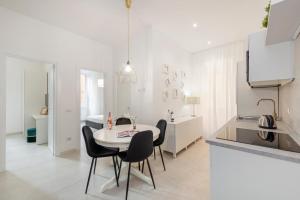 a white kitchen with a table and chairs in a room at White Flat Santa Croce in Rome