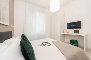 a bedroom with a white bed and a tv at White Flat Santa Croce in Rome +8 photos