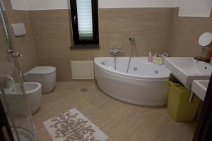 a bathroom with a tub and a toilet and a sink at Villa Mediterraneo in Fuscaldo