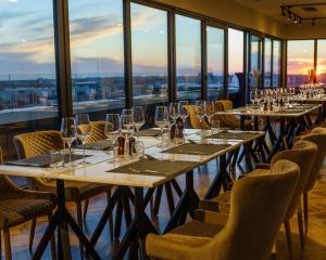 a restaurant with long tables and chairs and windows at Union Plaza Hotel in Bucharest