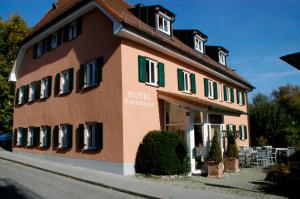 een groot bruin gebouw met groene luiken bij Hotel Fischerhaus in Starnberg