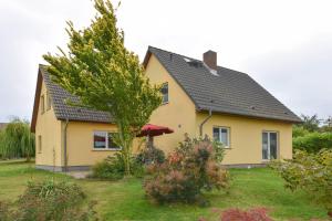 uma casa amarela com um telhado preto em Ferienhaus Inselnest em Pudagla
