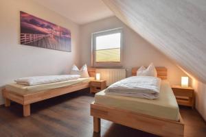 a bedroom with two beds and a window at Ferienhaus Inselnest in Pudagla