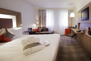 une chambre d'hôtel avec un lit et un salon dans l'établissement Novotel London Waterloo, à Londres 96 autres photos