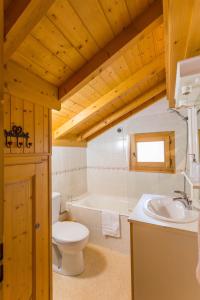 a bathroom with a toilet and a tub and a sink at Simply Morzine - Chalet Carving in Morzine