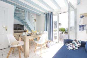 a kitchen and living room with a table and chairs at Résidence Odalys Valentin plage in Batz-sur-Mer