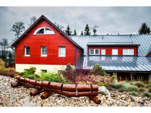 una casa roja y blanca con una roja en Rodinný resort UKO, en Bedřichov