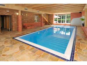 a large swimming pool in a house with a couch at Rodinný resort UKO in Bedřichov