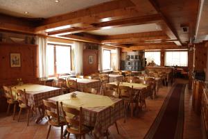 ein Restaurant mit Holztischen, Stühlen und Fenstern in der Unterkunft Hotel-Restaurant Zum Kirschbaum in Rottendorf