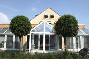 een gebouw met twee bomen ervoor bij Hotel-Restaurant Zum Kirschbaum in Rottendorf