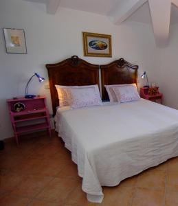 una camera con un grande letto bianco e un comodino di Acero Appartamenti a Manciano