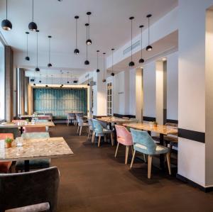 a restaurant with wooden tables and chairs at Hotel The Century in Hasselt