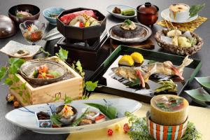 a table topped with plates of food and bowls of food at Wafu-no-Yado MASUYA in Yamanouchi