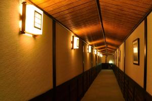 a hallway of a building with lights on the walls at Wafu-no-Yado MASUYA in Yamanouchi