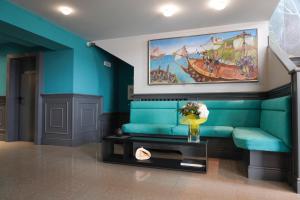 a living room with a blue couch and a painting at Sole Mare in Ventimiglia