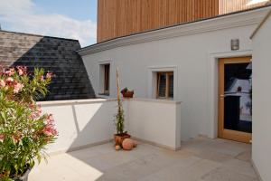 a white house with a potted plant on a patio at Deluxe Apartment Sonnleitner - ADULTS ONLY in Furth