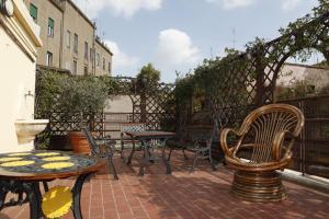 un patio con mesas y sillas y una valla en Hotel Adriatic, en Roma