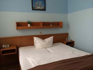 a bedroom with a bed with two shelves on the wall at Hotel Columbia in Berlin