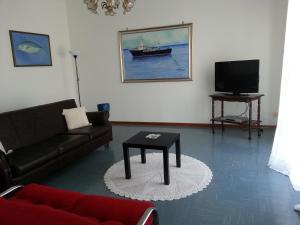 a living room with a couch and a tv at Appartamento Raggio Di Sole in Acireale