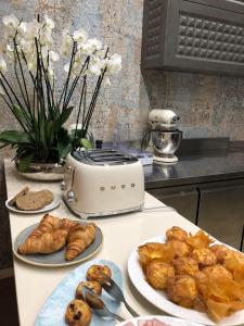 a table with plates of pastries and croissants on it at Impresamente Art Hotel in Sofia