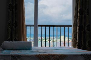 Gibzon's Invitation Suites near Mactan airport في ماكتان: غرفة نوم مع سرير وإطلالة على المحيط