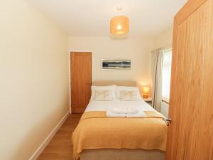 1 dormitorio con 1 cama con 2 toallas en Llain Bach en Llangefni