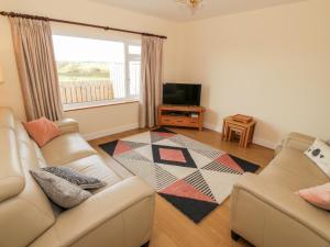 a living room with two couches and a television at Llain Bach in Llangefni