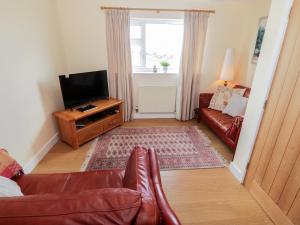 sala de estar con sofá y TV en Llain Mai en Llangefni