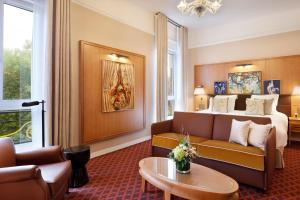 a hotel room with a couch and a bed at Hôtel Barrière Le Westminster in Le Touquet-Paris-Plage