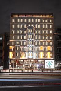 Un grand bâtiment avec des lumières allumées la nuit dans l'établissement Grand Halic Goldenhorn, à Istanbul