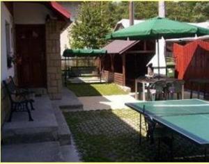 un patio con una mesa y una sombrilla verde en Chalupa u Drába, en Oščadnica