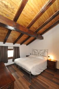 a bedroom with a large bed with wooden ceilings at Hosquet Lodge in Breuil-Cervinia