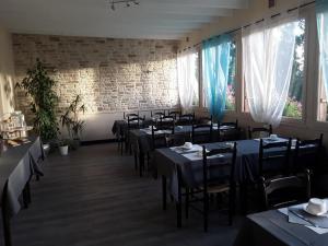 a room with tables and chairs in a restaurant at Hotel des Voyageurs in Payzac