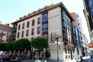 un grande edificio in una strada di città con persone sul marciapiede di Hotel Mozart a Valladolid