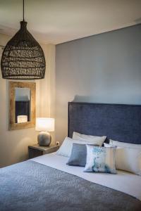 a bedroom with a large bed with a blue headboard at Deluxe Kefalonia Apartment Apartment Myrtillo 1 Bedroom Pool Sea View Karavomilos in Karavomylos