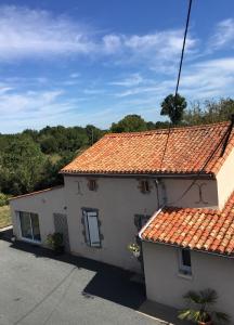 une maison blanche avec un toit en carrelage orange dans l'établissement Gîte au Haras, à Les Aubiers