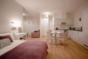 Cette chambre comprend un lit, une table et une cuisine. dans l'établissement Apartment 2, Isabella House, Aparthotel, By RentMyHouse, à Hereford