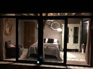 1 dormitorio con cama y espejo en Casa Rural Atelier - Jardin, Wifi, Aire acondicionado y netflix, en Velliza