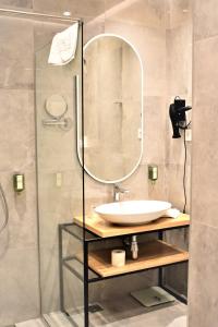 y baño con lavabo y ducha con espejo. en Korpa Deli Rooms, en Novi Sad
