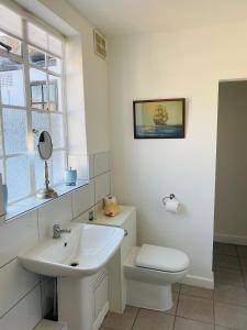 a white bathroom with a sink and a toilet at The Old Court Hotel in Witney