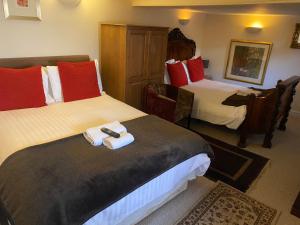 a hotel room with two beds with towels on them at The Old Court Hotel in Witney