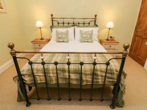 een antiek bed in een slaapkamer met 2 lampen bij Nutkin Cottage in Windermere