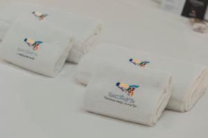 a pile of white towels sitting on a table at Sicilia's Art Hotel & Spa in Acitrezza