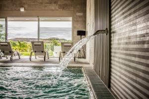 a pool with a water fountain in a house at Hotel Tudanca-Aranda II in Aranda de Duero