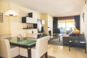 uma sala de estar com uma mesa e cadeiras e um sofá em Espacioso apartamento en Guadalmina - Marbella em Marbella