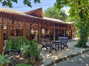 a patio with chairs and a table in front of a building at Pousada Casa de Praia in Praia do Forte