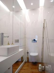 a white bathroom with a sink and a toilet at Luxury Beato Trendy Location in Lisbon