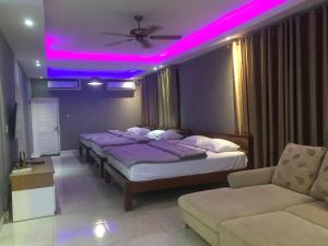 um quarto com 2 camas e uma iluminação roxa em Sealife Private Beach Villa em Ban Nong Si Tong
