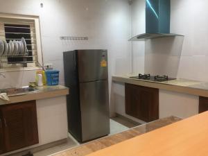 uma cozinha com um frigorífico de aço inoxidável e um lavatório em Sealife Private Beach Villa em Ban Nong Si Tong
